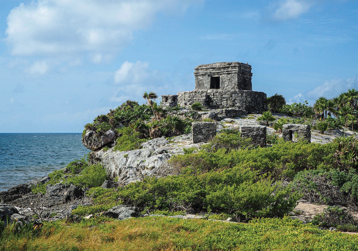 a stone structure on a rocky outcrop near the ocean