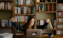woman in black long sleeve shirt sitting in front of silver macbook